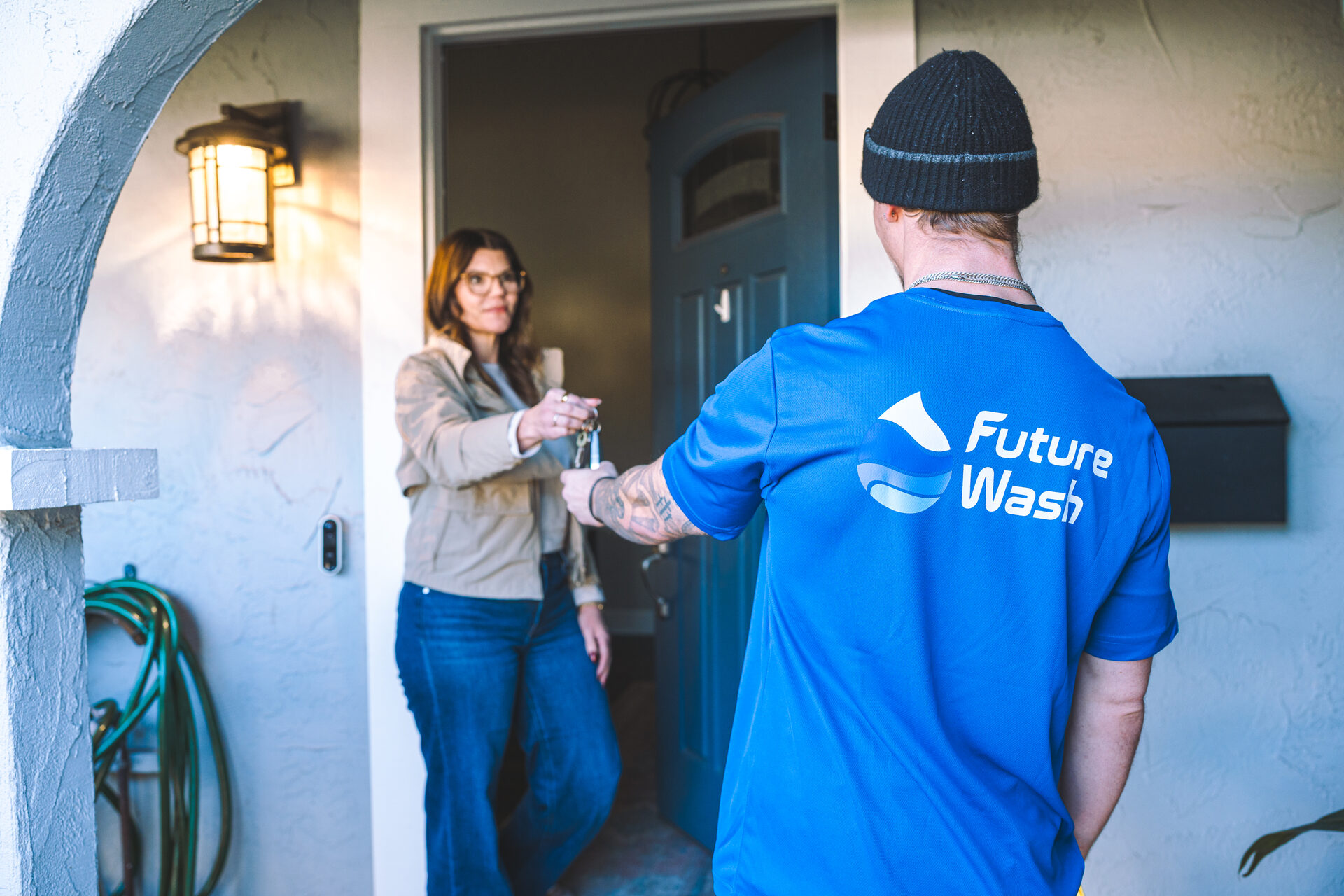 Customer handing keys to a Future Wash technician at her front door